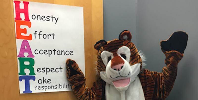 Shakey, the Shaker Lane School mascot, presents the long-standing core values of H.E.A.R.T.